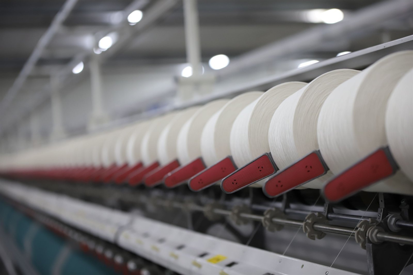 A row of yarn packages on a spinning frame in a working textile mill